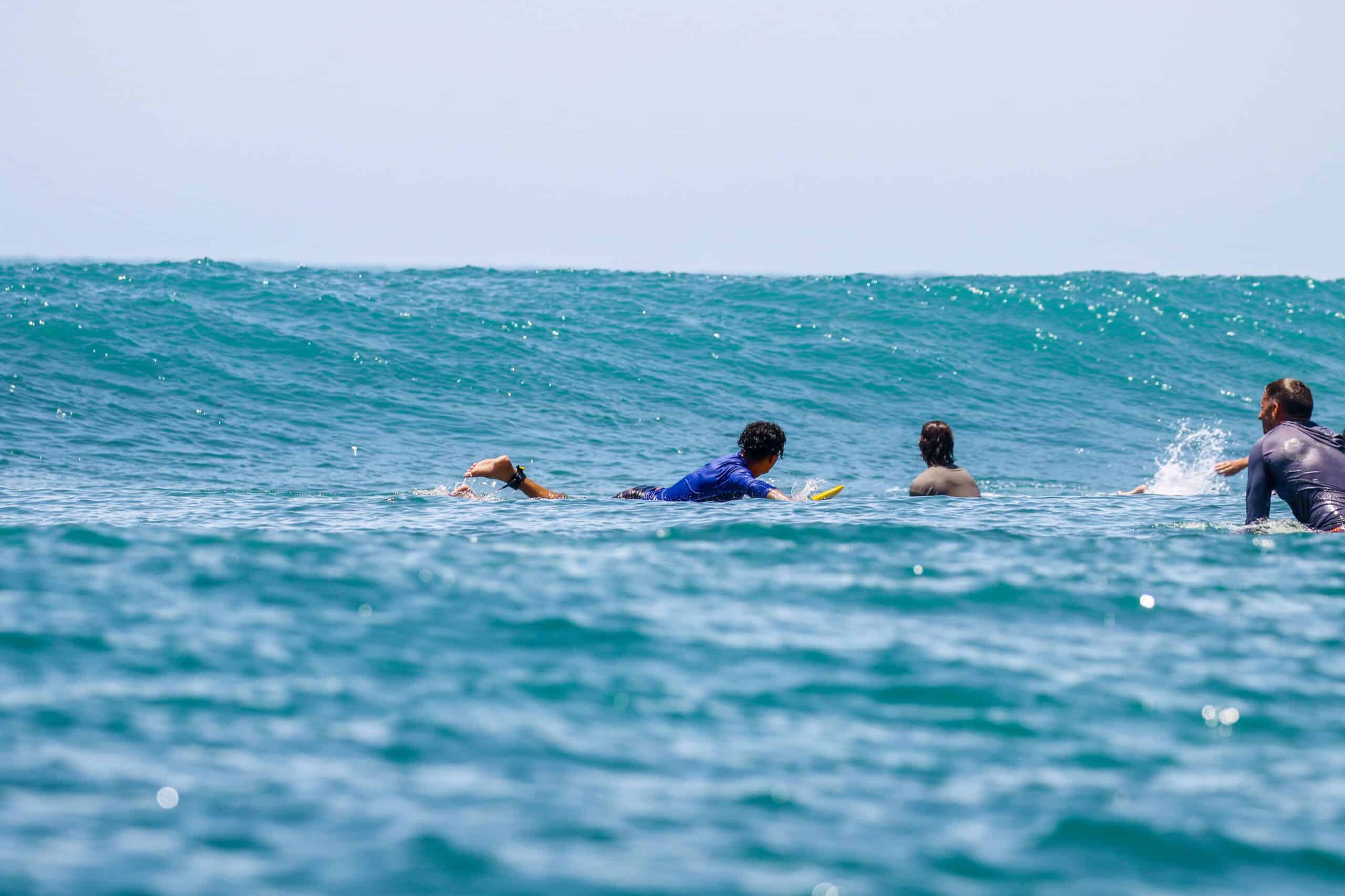 Surfer riding a wave during a G-Land surf trip in East Java, Indonesia